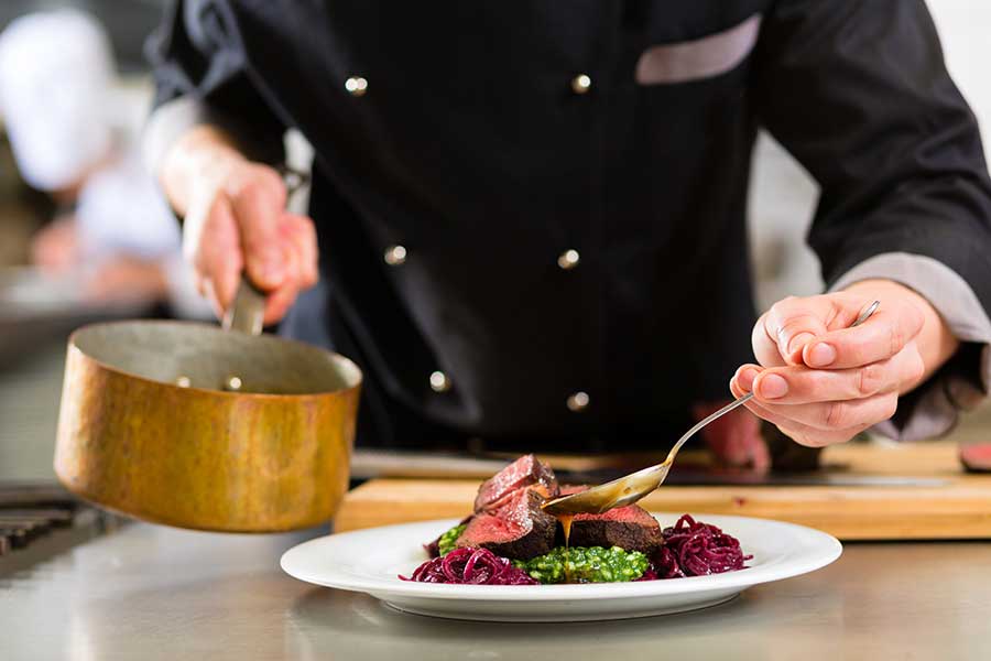 Chefin chef in action - plating a meal