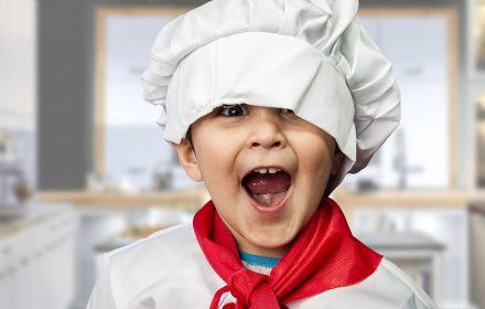 a happy kid with a chef hat