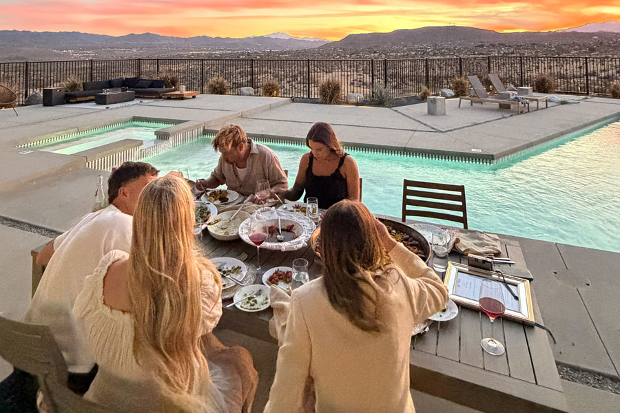 a bunch of guests sitting outdoor next to a swimming pool