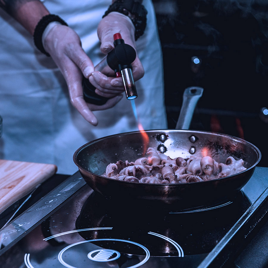 Chef with burner, food on pan