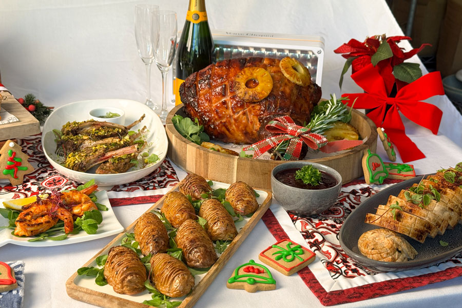 Christmas feast with roast turkey, savoury pastries, vegetables and festive table decorations.