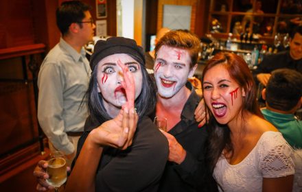 halloween party fun crowd looking at a chicken feet canape