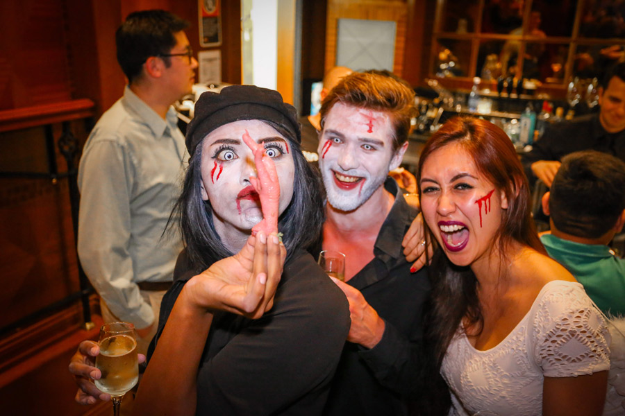 halloween party fun crowd looking at a chicken feet canape
